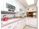 White kitchen featuring granite countertops, tiled backsplash, stainless steel sink, and white appliances at 300 Glennes Ln # 208, Dunedin, FL 34698