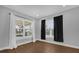 Light-filled bedroom with two windows dressed in elegant curtains and wood-look flooring at 321 W Wilder Ave, Tampa, FL 33603