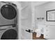 A compact laundry area steps away from an updated bathroom and featuring a modern stacked washer and dryer at 321 W Wilder Ave, Tampa, FL 33603