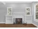 Cozy living room with a white brick fireplace, built-in shelving, and natural light from two windows at 321 W Wilder Ave, Tampa, FL 33603