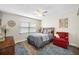 Guest bedroom with wood floors, ceiling fan and red armchair at 4043 93Rd N Ter, Pinellas Park, FL 33782