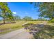 Gravel road leads through a grassy area with mature trees at 4043 93Rd N Ter, Pinellas Park, FL 33782