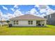 Beautiful backyard showing lush green grass, a covered lanai, and the home's exterior under a partly cloudy sky at 4107 112Th E St, Palmetto, FL 34221