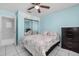 Bedroom features tile floor, closet with mirror doors, ceiling fan, and side table at 4414 W Paris St, Tampa, FL 33614