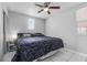 This bedroom has a ceiling fan, window, and clean tile flooring with a modern bed and end table at 4414 W Paris St, Tampa, FL 33614