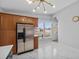 Bright kitchen with stainless steel refrigerator, white tile floors, and large window at 4414 W Paris St, Tampa, FL 33614