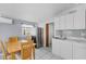 Bright kitchenette featuring stainless steel refrigerator, table with chairs, and white cabinets at 4414 W Paris St, Tampa, FL 33614