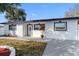 Charming single-story home featuring a modern white exterior, dark trim and a well maintained lawn at 4716 Eldorado Dr, Tampa, FL 33615