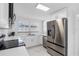 Bright modern white kitchen with stainless steel appliances and marble floors at 4716 Eldorado Dr, Tampa, FL 33615