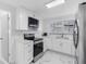 Modern white kitchen with stainless steel appliances and marble countertops at 4716 Eldorado Dr, Tampa, FL 33615