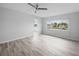 Bedroom featuring wood-look floors, neutral walls, ceiling fan, and an adjacent doorway at 4725 Cove Cir # 202, St Petersburg, FL 33708