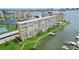 Condominium exterior showcasing waterfront views, manicured landscaping, and private boat dock at 4725 Cove Cir # 202, St Petersburg, FL 33708