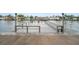 Dock view of a well maintained gray wooden dock on a canal with railing and seats at 4725 Cove Cir # 202, St Petersburg, FL 33708