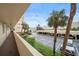 View from the walkway of the parking area with visible spaces and palm trees in the background at 4725 Cove Cir # 202, St Petersburg, FL 33708