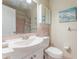 A full bathroom with a white sink, toilet, and pink tile shower at 5246 81St N St # 6, St Petersburg, FL 33709