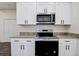 Close-up of the kitchen showing new stainless steel appliances, stone countertops and white cabinets at 5885 114Th N Ter, Pinellas Park, FL 33782