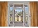 Inviting balcony view through French doors with yellow curtains, showcasing the neighborhood at 6010 17Th S Ave, Gulfport, FL 33707