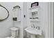 Cozy bathroom with white fixtures, pedestal sink, and charming wall cabinets for storage at 6010 17Th S Ave, Gulfport, FL 33707