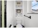 Elegant bathroom featuring a toilet with a modern design and neatly organized storage shelves at 6010 17Th S Ave, Gulfport, FL 33707