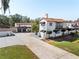 Exterior view of a home featuring a long driveway, two-car garage, red tile roof, and manicured landscaping at 6010 17Th S Ave, Gulfport, FL 33707