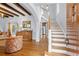 Inviting foyer with hardwood floors, staircase, exposed wood beams, and an arched doorway leading to the kitchen at 6010 17Th S Ave, Gulfport, FL 33707