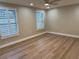 Neutral bedroom featuring wood flooring, white walls, and shuttered windows at 7281 Channelside N Ln, Pinellas Park, FL 33781