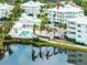 An aerial view of the Condo community, featuring a pool, lush landscaping, and water views at 7611 34Th W Ave # 303, Bradenton, FL 34209