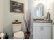 Powder room featuring sleek vanity, oval mirror, stylish decor, and a framed nature print at 7611 34Th W Ave # 303, Bradenton, FL 34209