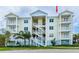 Condominium exterior featuring a classic design with white railings, tropical landscaping, and a coastal color scheme at 7611 34Th W Ave # 303, Bradenton, FL 34209