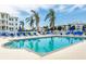 Community swimming pool with blue lounge chairs, palm trees, and well-maintained landscaping at 7611 34Th W Ave # 303, Bradenton, FL 34209