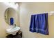 Charming half bathroom featuring a vessel sink, oval mirror, and a bright blue towel at 780 Spring Flowers Trl, Brandon, FL 33511