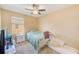 Cozy bedroom with a white iron bed, daybed, ceiling fan, and a window view at 780 Spring Flowers Trl, Brandon, FL 33511