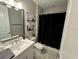 Well-lit bathroom featuring a shower with a black curtain, a white vanity, and modern fixtures at 923 Seagrape Dr, Ruskin, FL 33570