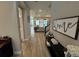 Inviting foyer with wood-look tile flooring, a console table, and a glimpse of the living room beyond at 923 Seagrape Dr, Ruskin, FL 33570