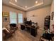 A well-lit home office with a tray ceiling, modern desk, and comfortable seating at 923 Seagrape Dr, Ruskin, FL 33570