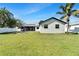 Beautiful backyard featuring lush lawn, fire pit, white fence, and screened-in lanai for relaxing at 9693 58Th N St, Pinellas Park, FL 33782