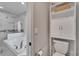 Modern bathroom featuring a soaking tub, storage cabinet and shelving, and a toilet with chrome hardware at 9693 58Th N St, Pinellas Park, FL 33782