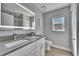 Modern bathroom featuring double sinks with gray countertops and a large, lighted mirror at 9693 58Th N St, Pinellas Park, FL 33782