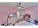 Pink bedroom with light colored wood floors, a ceiling fan and a white dresser at 9693 58Th N St, Pinellas Park, FL 33782