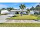 Charming home with a manicured lawn, mature palm tree, and a neatly paved driveway at 9693 58Th N St, Pinellas Park, FL 33782