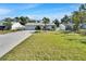 Inviting single-story home featuring a well-manicured lawn, mature landscaping and a long concrete driveway at 9693 58Th N St, Pinellas Park, FL 33782