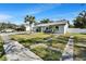 Beautifully landscaped front yard with green grass, sidewalk, modern white fence, and palm tree at 9693 58Th N St, Pinellas Park, FL 33782