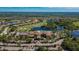 An aerial view of a clubhouse surrounded by verdant landscaping, a golf course, and beautiful water features at 1004 Regal Manor Way, Sun City Center, FL 33573