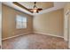 Spacious bedroom with decorative tray ceiling, ceiling fan, neutral walls, and tiled floor at 1004 Regal Manor Way, Sun City Center, FL 33573