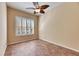 Comfortable bedroom with tile flooring, plantation shutters, and a modern ceiling fan at 1004 Regal Manor Way, Sun City Center, FL 33573