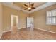 Bedroom featuring neutral walls, tiled floor, ceiling fan, shuttered window, and doorways to multiple rooms at 1004 Regal Manor Way, Sun City Center, FL 33573