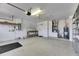 Clean garage with an electric garage door opener, shelving, and utility connections at 1004 Regal Manor Way, Sun City Center, FL 33573