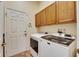 Well-equipped laundry room with modern washer, dryer, and ample storage cabinets at 1004 Regal Manor Way, Sun City Center, FL 33573