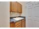 Functional laundry room with a utility sink, plenty of cabinet storage, and neutral decor at 1004 Regal Manor Way, Sun City Center, FL 33573