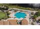 Aerial view of a large pool with many chairs surrounded by lush landscaping and sidewalks, perfect for community enjoyment at 1004 Regal Manor Way, Sun City Center, FL 33573